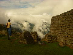 Turista gazing out into the valley from the top of Machu Picchu